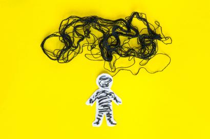 Negative thinking concept, paper man and black thread on the yellow background.