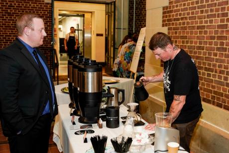 man pouring coffee for a guest at an event